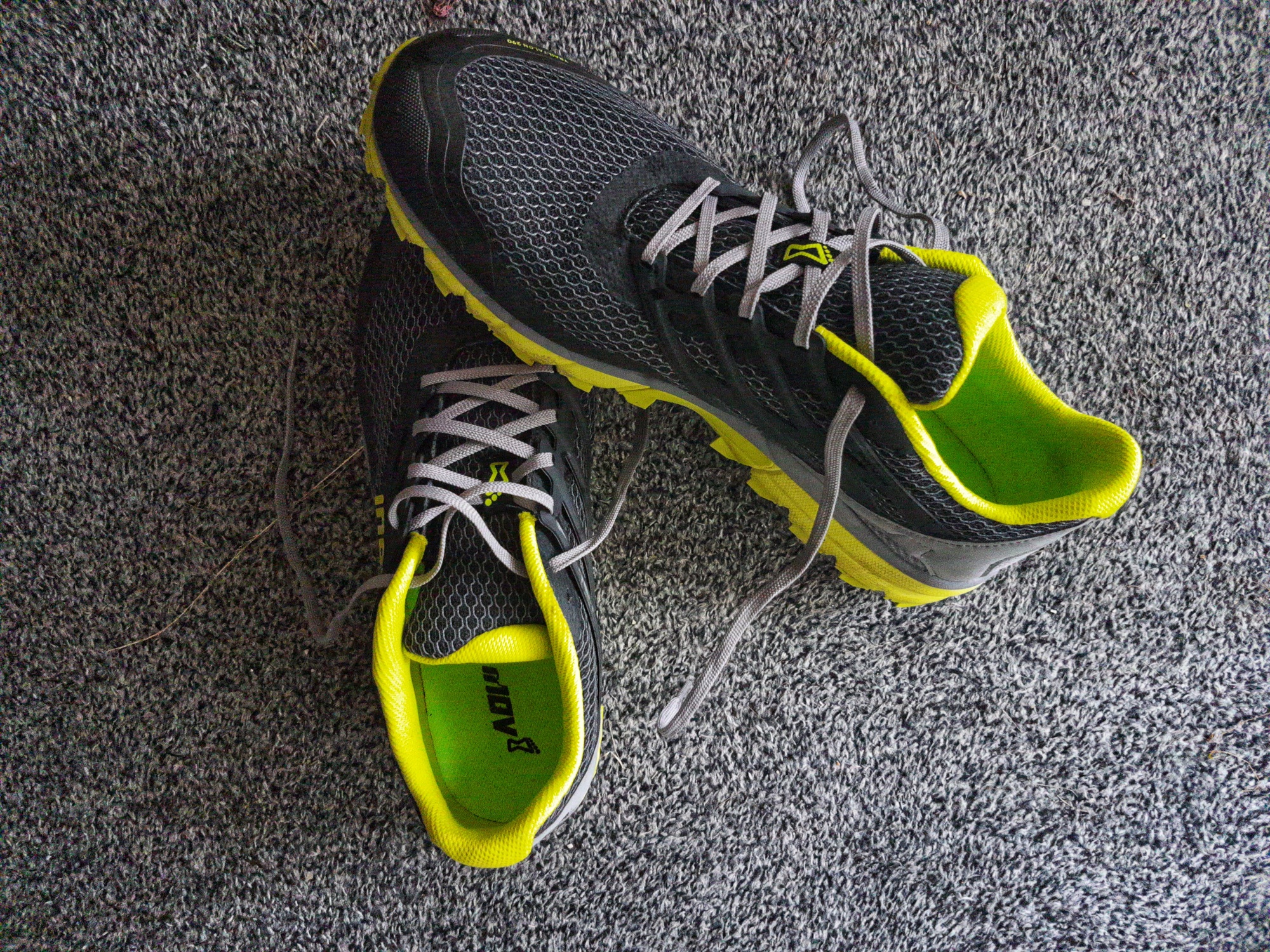 Black-Yellow running shoe pair. The right shoes stands with its tip on the left shoes