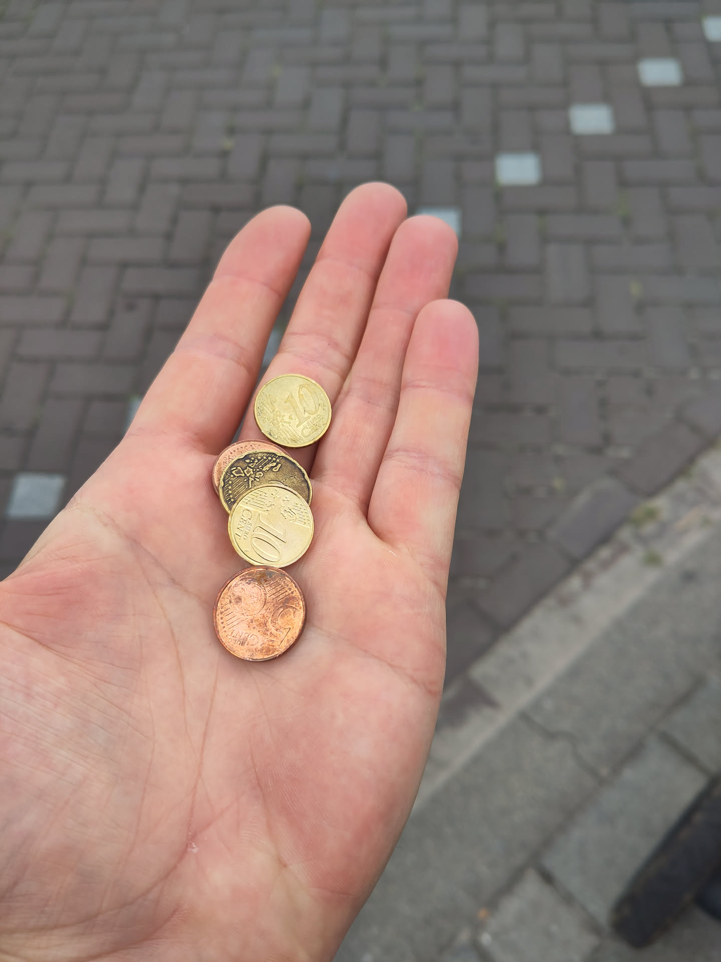 My hand holding a handful of coins in the hand