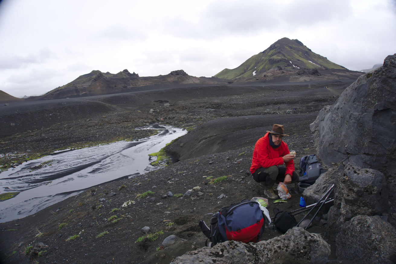 Hungry Felix eating bread in the middle of a black volcanic landscape